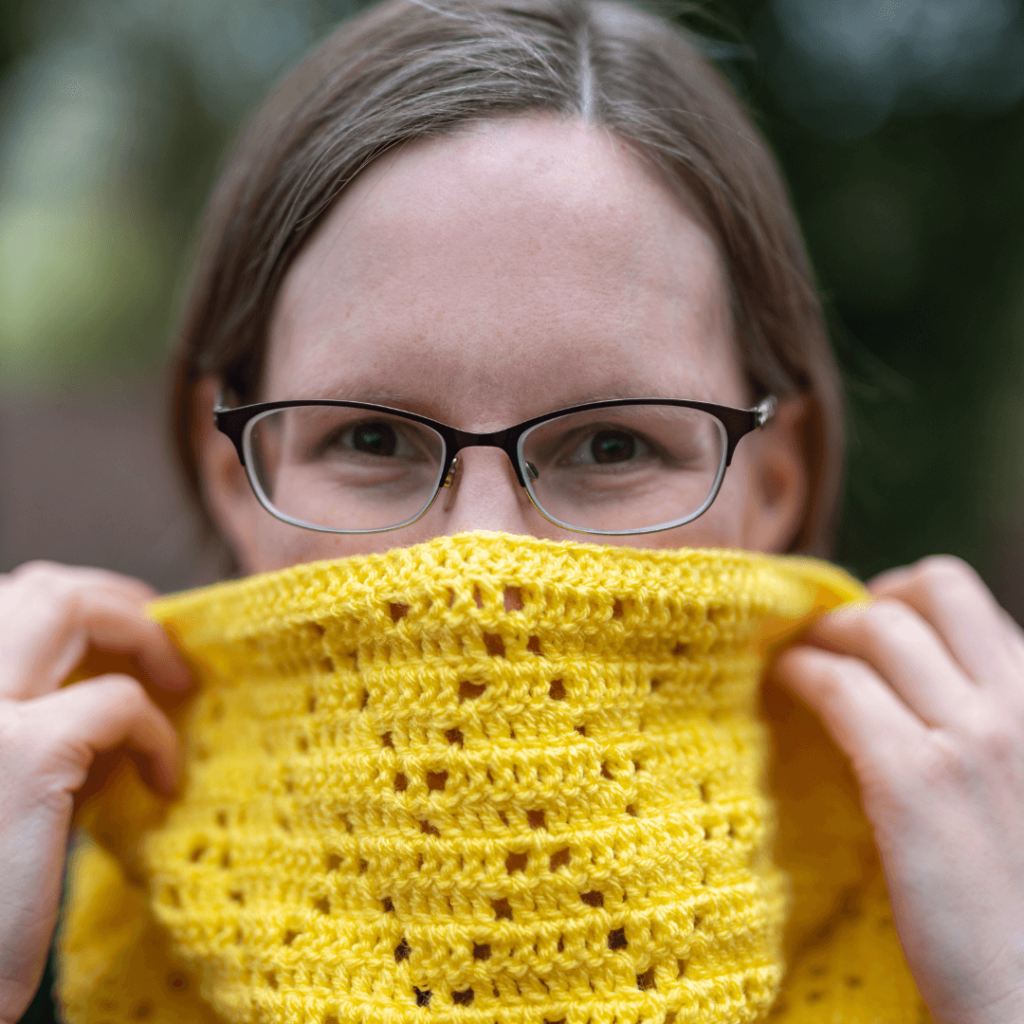 Smiling woman yellow crochet scarf